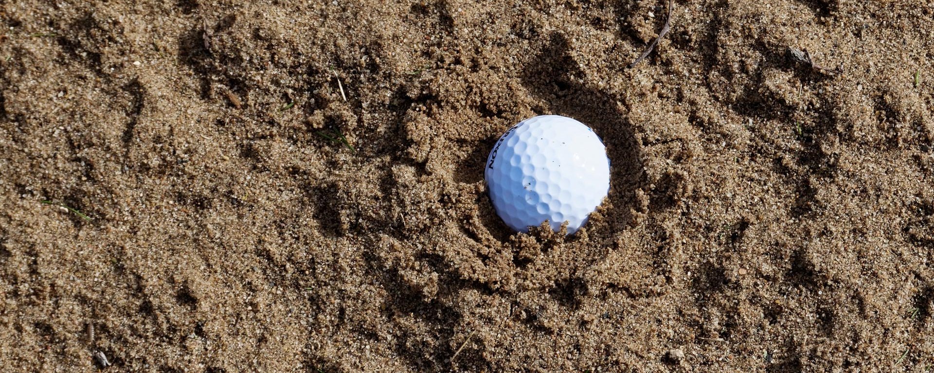 Ein Golfball liegt in einem Sand-Bunker auf dem Golfplatz des Allgäuer Golf- und Landclub e.V. in Ottobeuren und steht sinnbildlich für eine in den Sand gesetzte Suche, welche den Website-Besucher auf diese 404-Seite geführt hat